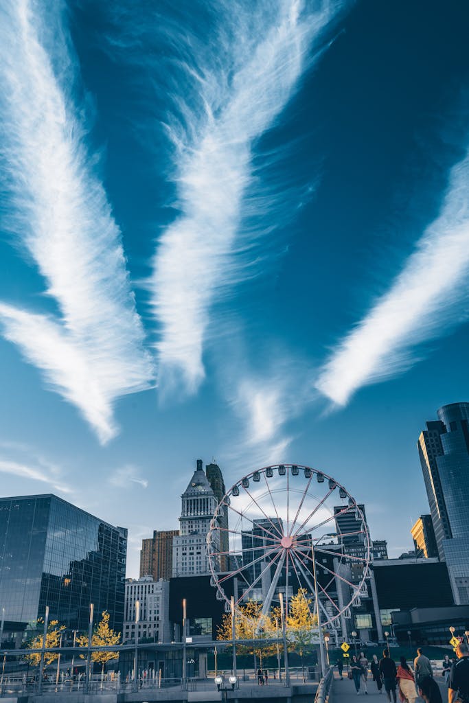 Cincinnati skyline featuring a ferris wheel and modern architecture under a dramatic sky.